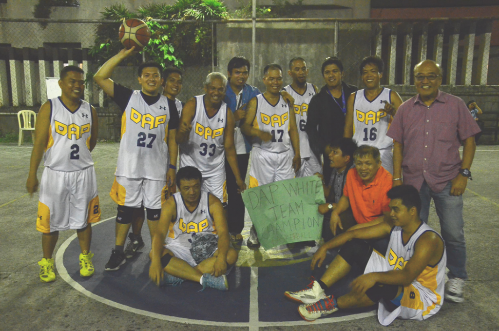 Members of the champion White team bask in victory after their 66-65 win over Red that gave them the championship in the DAP basketball tournament.  